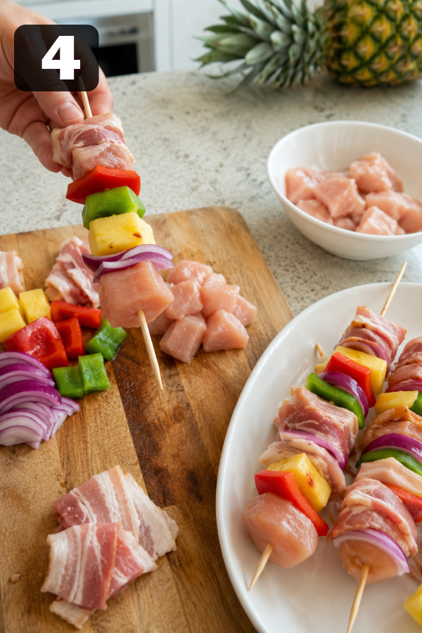 Chicken, bacon, pineapple, peppers, and onion threaded onto wooden skewers