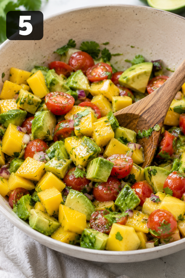 Fresh avocado mango salad gently tossed with lime dressing and ready to serve.