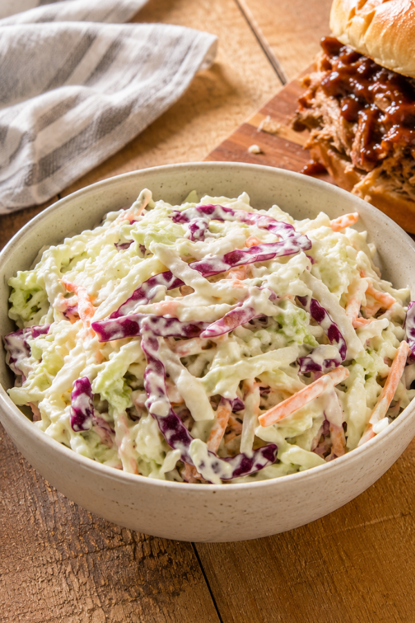 Fresh coleslaw with shredded cabbage, carrots, herbs, and a light creamy summer dressing
