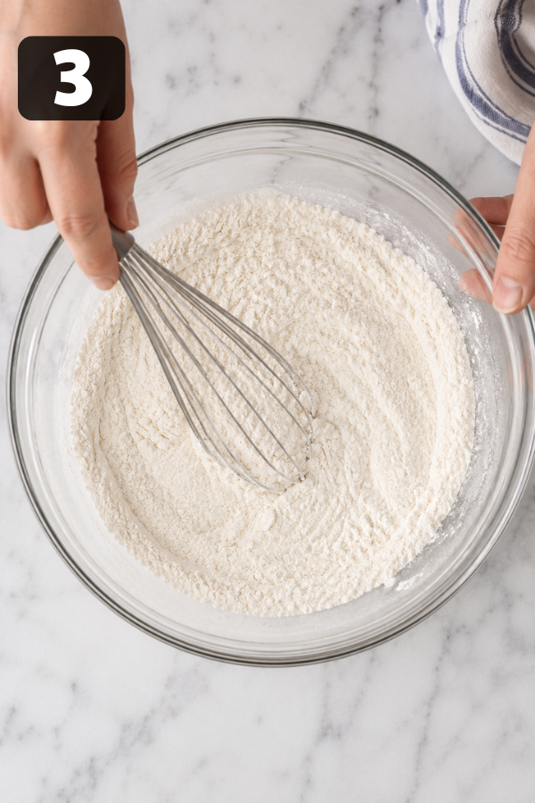 Whisking dry ingredients including flour, baking powder and salt for loaf cake base