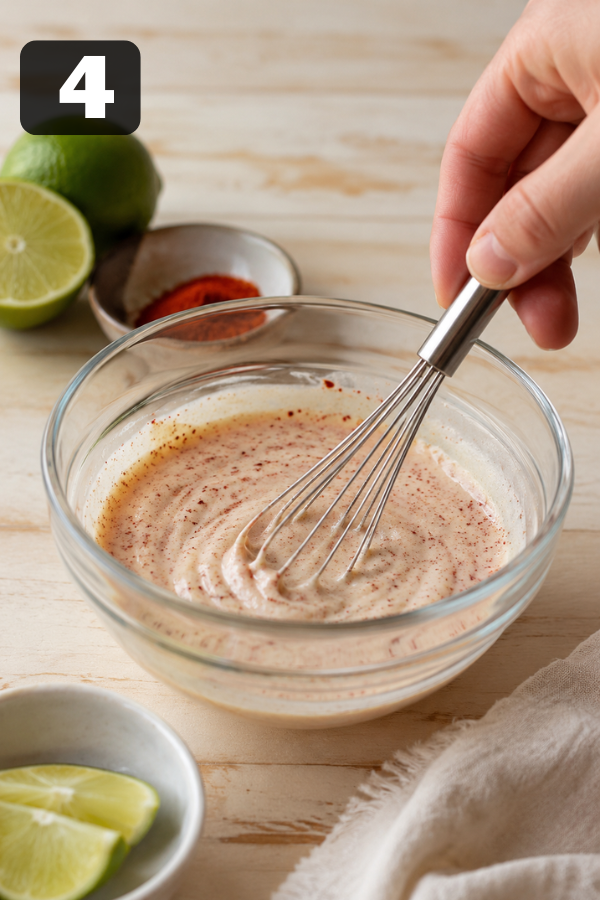 Lime-chili sauce being whisked with Greek yogurt, lime juice, honey, chili powder, garlic powder, and sriracha.