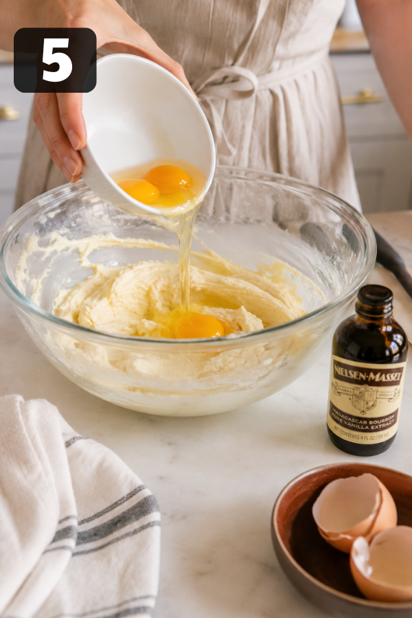 Adding eggs and vanilla extract into creamed butter mixture for cake batter
