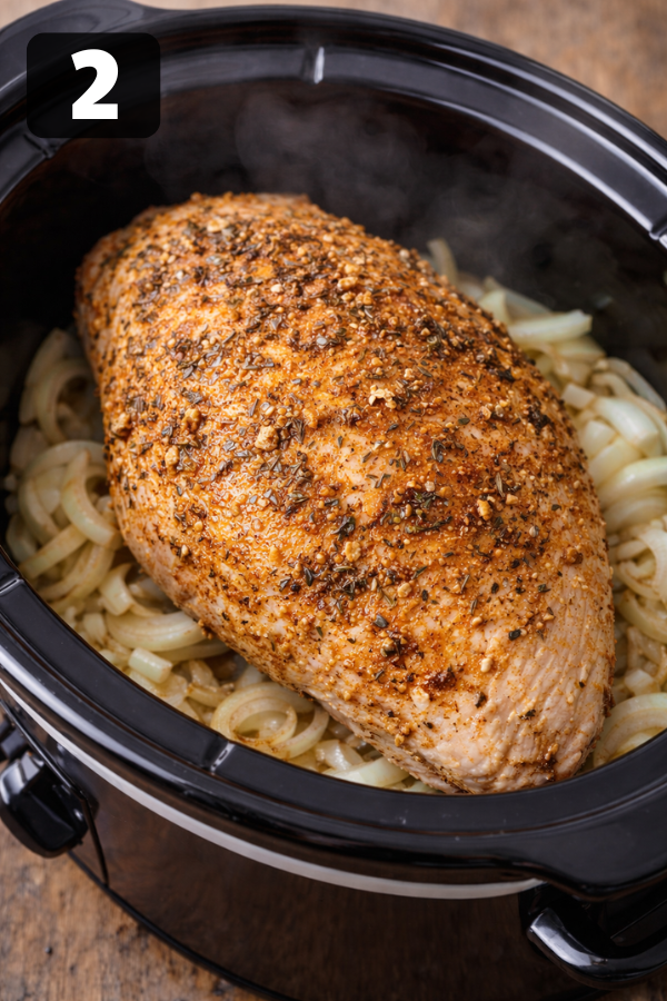 placing seasoned turkey breast on sliced onions in crockpot