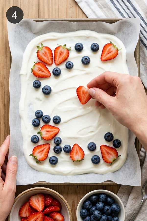 placing berries on frozen yogurt bark before freezing