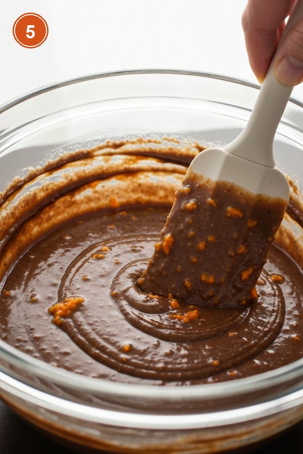 Step 5: Folding flour mixture into dark brown carrot batter with rubber spatula