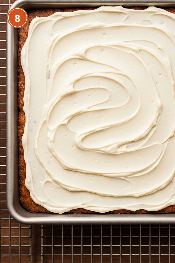 Step 8: Spreading cream cheese frosting over cooled carrot cake bars with offset spatula