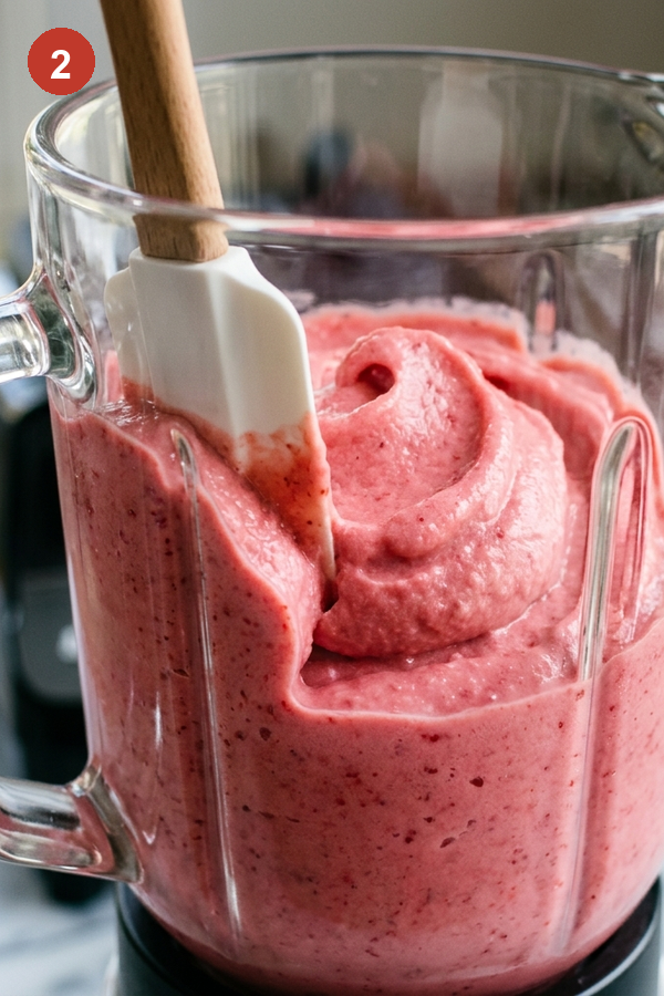 thick pink strawberry mixture in blender like soft serve