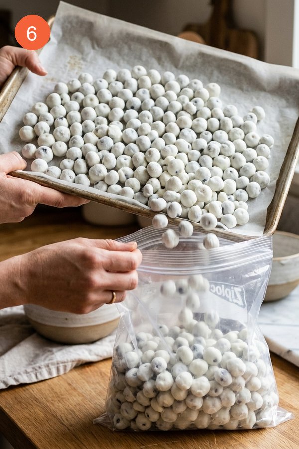 pouring frozen yogurt blueberry bites into freezer bag