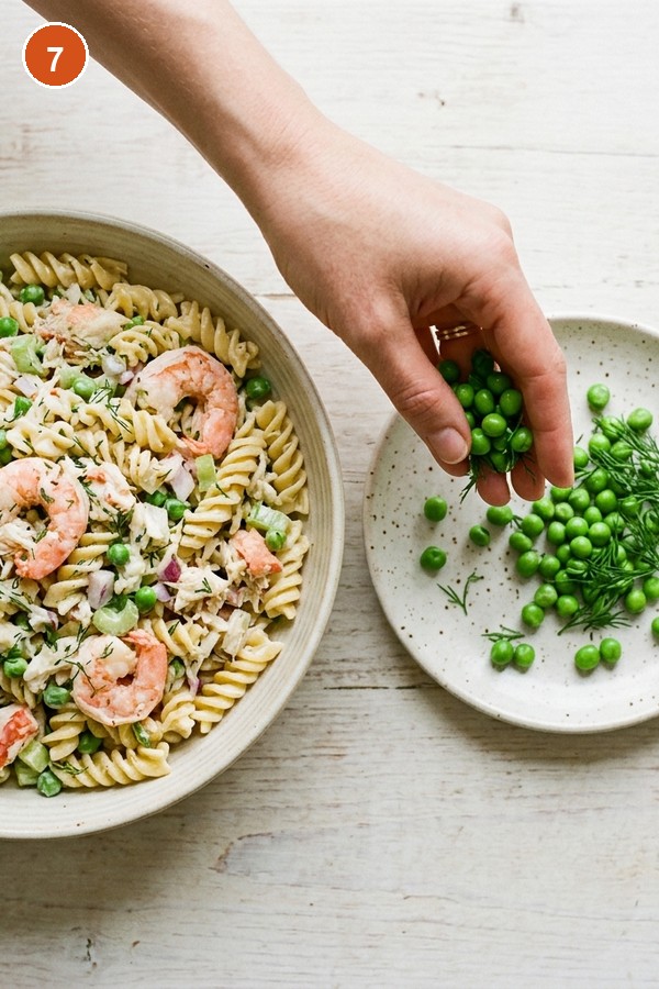 reserving fresh dill and peas for seafood pasta salad garnish